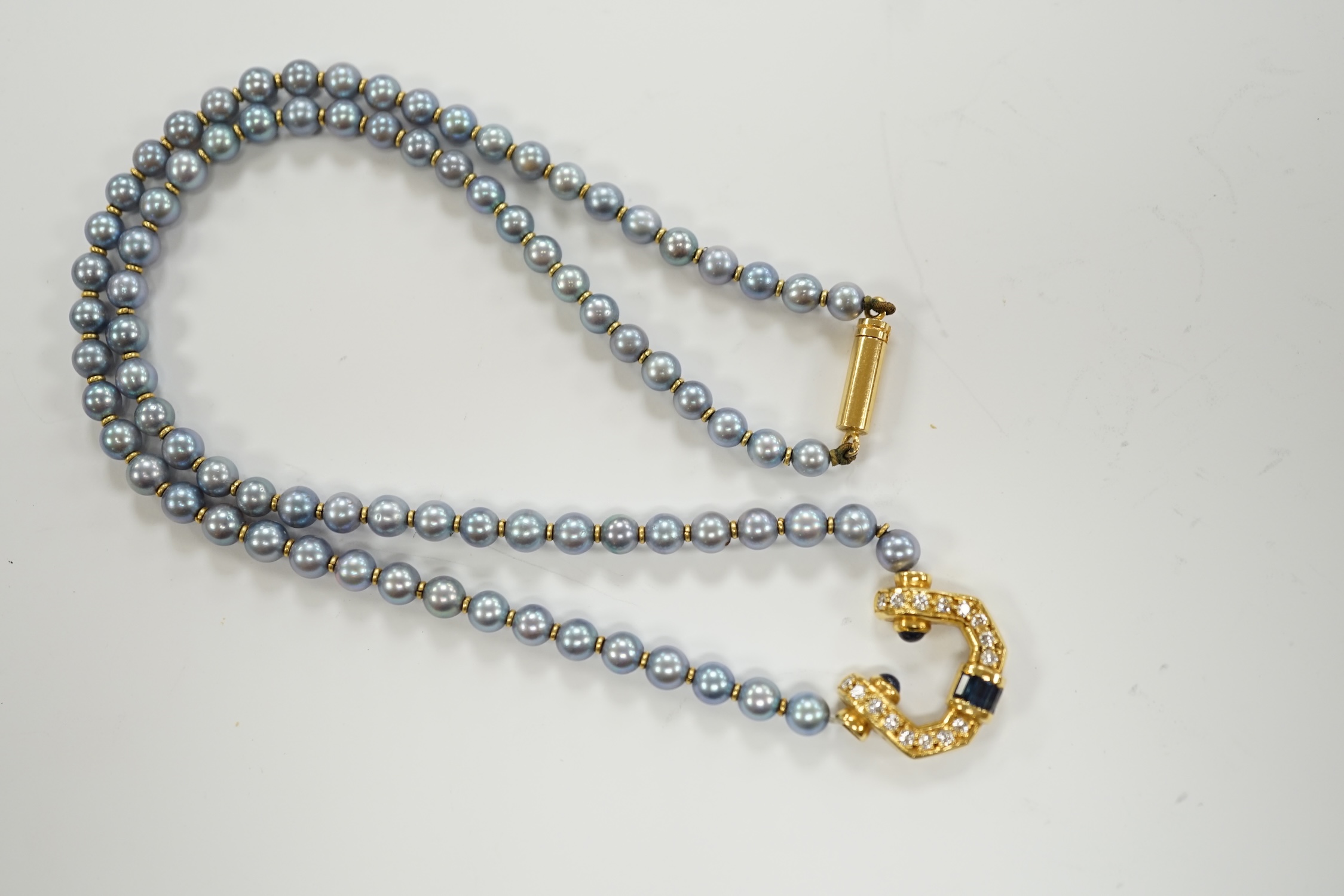 A modern single strand blue cultured pearl necklace, with 750 yellow metal, sapphire and diamond set pendant and yellow metal clasp, 42cm.